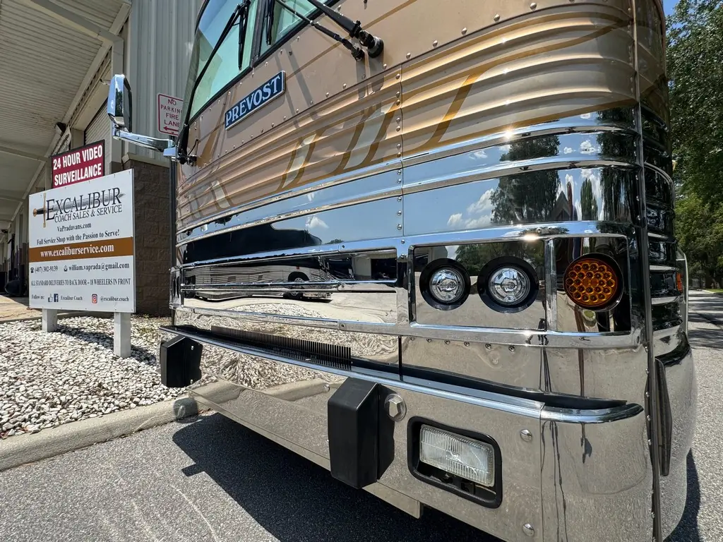 Front end of the 1999 Vogue Prevost XL outside the Excalibur Coach shop